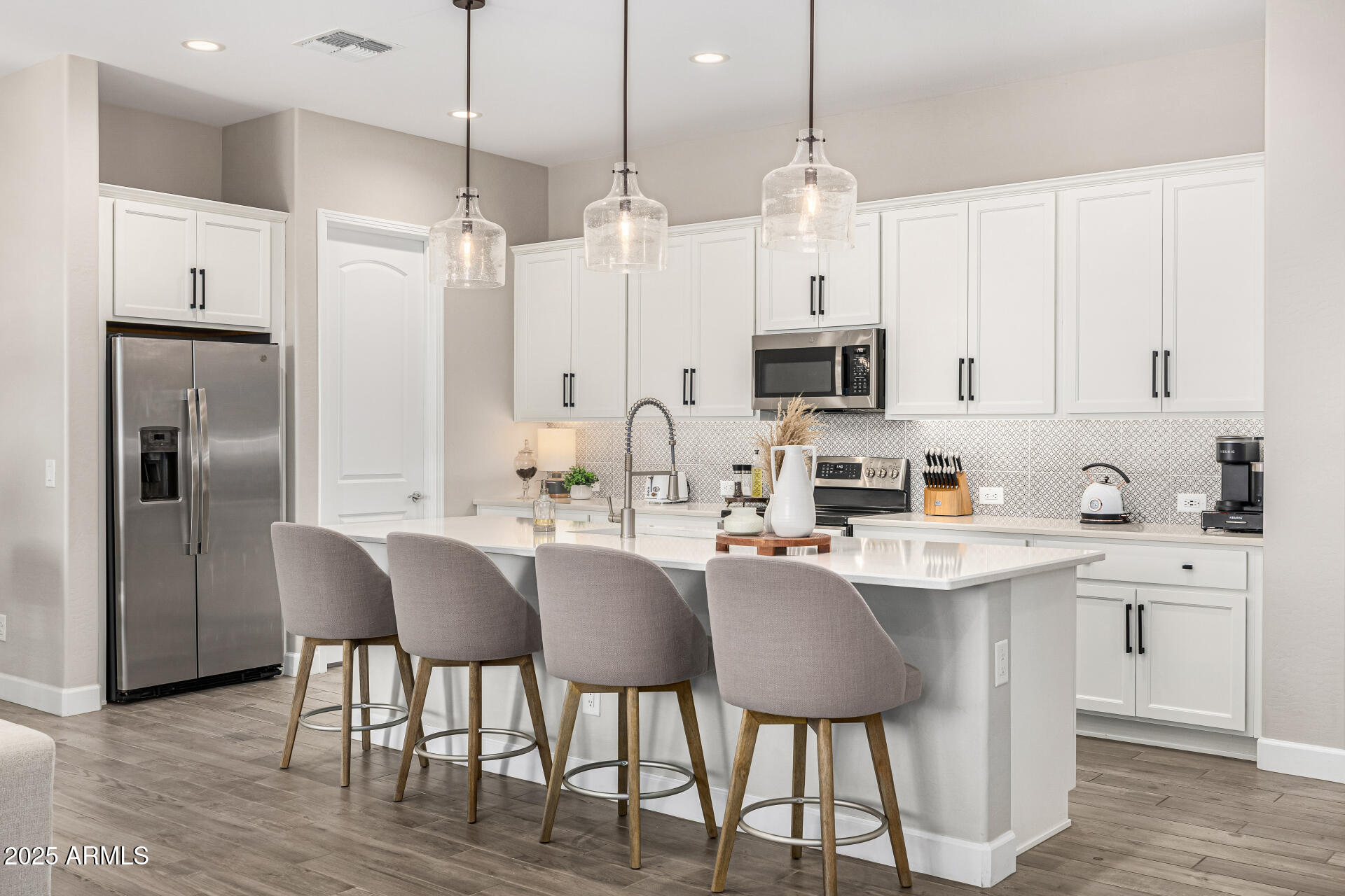 16897 West Merrell Street Goodyear, AZ 85395 - Photo 7 of 21 a kitchen with stainless steel appliances granite countertop a sink a microwave a refrigerator and white cabinets