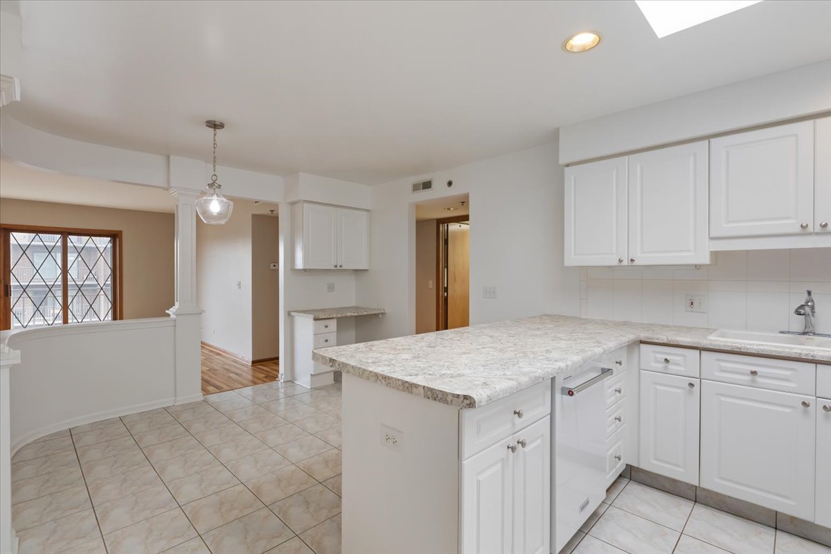 5 South Pine Street, Unit 509 Mount Prospect, IL 60056 - Photo 12 of 31 a kitchen with white cabinets appliances and chandelier