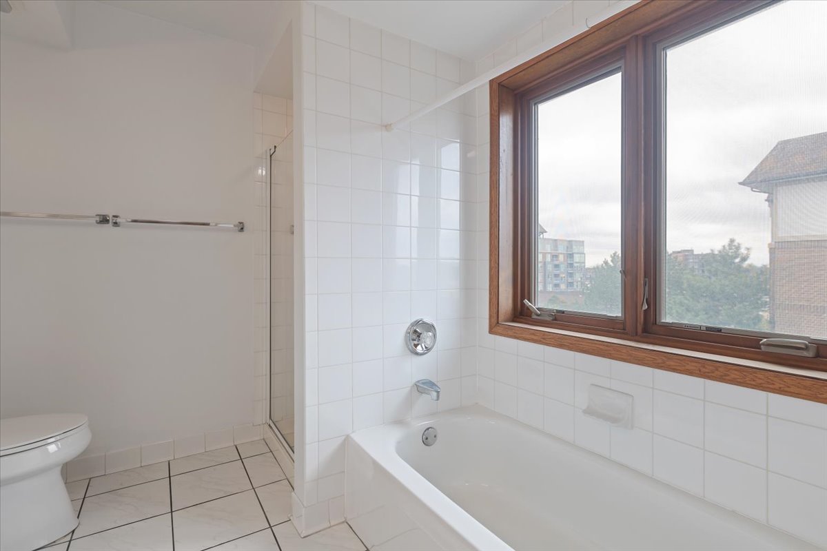 5 South Pine Street, Unit 509 Mount Prospect, IL 60056 - Photo 18 of 31 a white bath tub sitting next to a toilet
