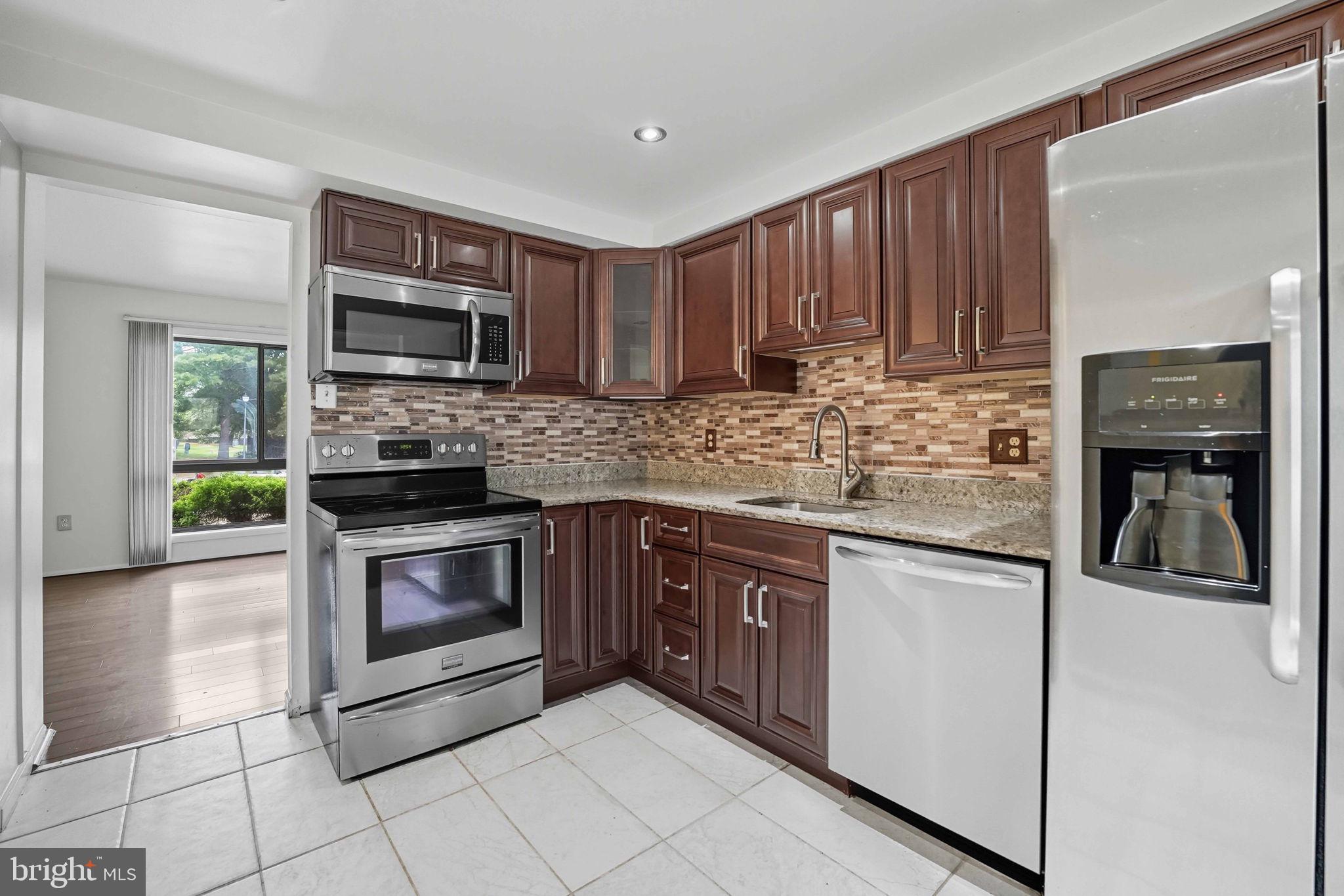 258 North Cottage Road Sterling, VA 20164 - Photo 9 of 33 a kitchen with stainless steel appliances granite countertop a stove microwave and sink