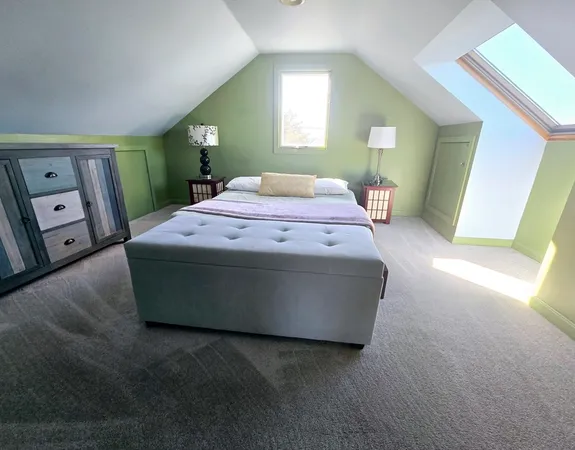 a spacious bedroom with a bed and a mirror