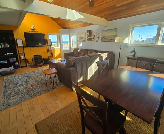 a living room with furniture a flat screen tv and a large window