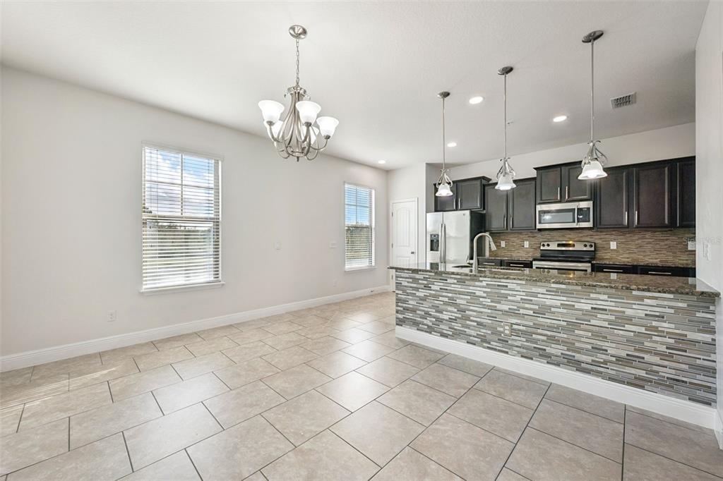 10866 Sunset Ridge Lane Orlando, FL 32832 - Photo 21 of 74 a large kitchen with kitchen island granite countertop a stove a sink and a granite counter top