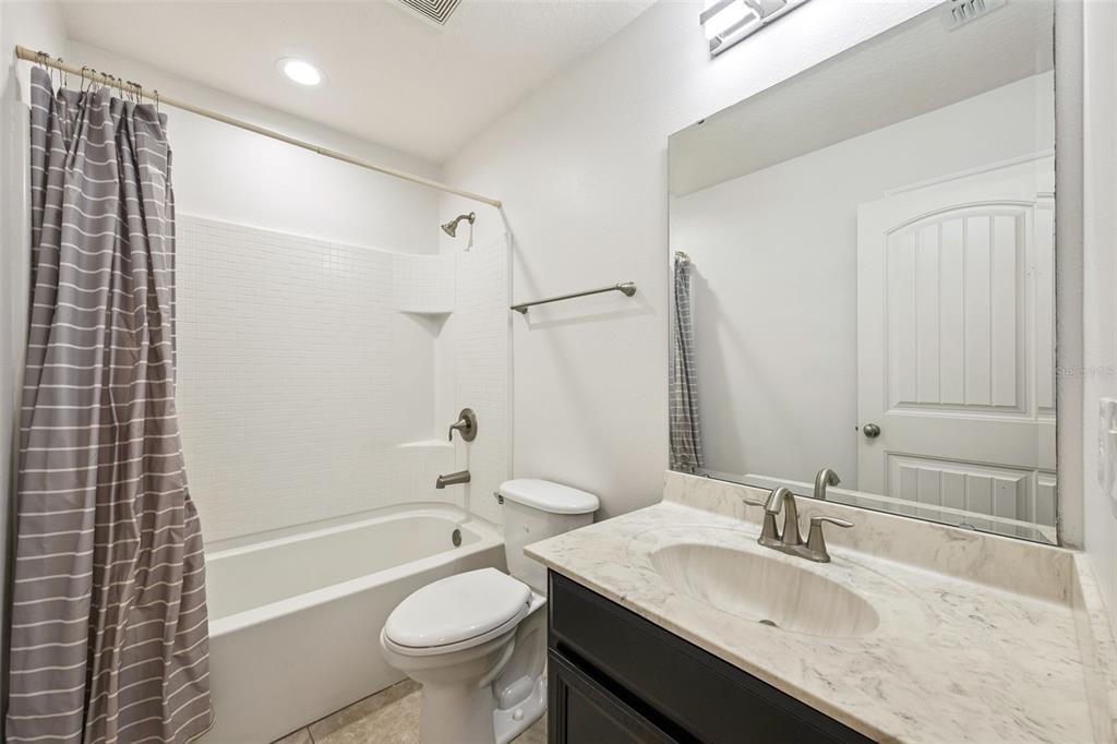 10866 Sunset Ridge Lane Orlando, FL 32832 - Photo 38 of 74 a bathroom with a granite countertop sink a toilet and shower