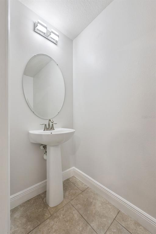 10866 Sunset Ridge Lane Orlando, FL 32832 - Photo 40 of 74 a bathroom with a sink a mirror and vanity