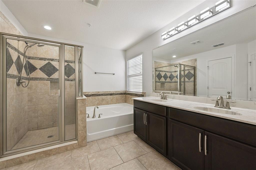 10866 Sunset Ridge Lane Orlando, FL 32832 - Photo 6 of 74 a bathroom with a double vanity sink a large mirror and shower