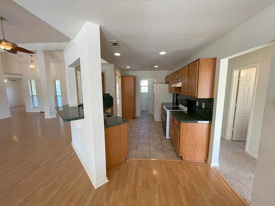 1111 Pine Ranch Road Seguin, TX 78155 - Photo 24 of 50 Kitchen and hall to 2 bedrooms on right. Laundry room is in back, beyond kitchen.