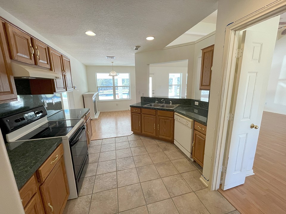 1111 Pine Ranch Road Seguin, TX 78155 - Photo 25 of 50 Kitchen features formica counters, tile floors, wood cabinets, electric oven