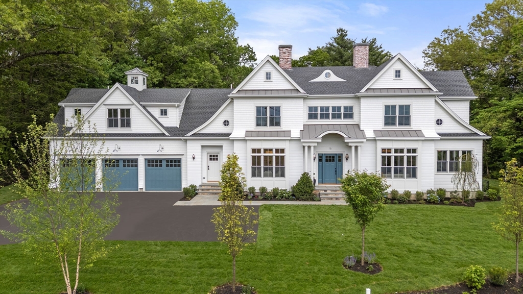 a front view of a house with a yard and potted plants