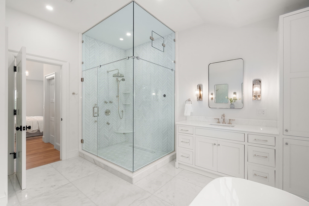 15 Lathrop Road Wellesley, MA 02482 - Photo 25 of 40 a bathroom with a shower sink vanity and mirror