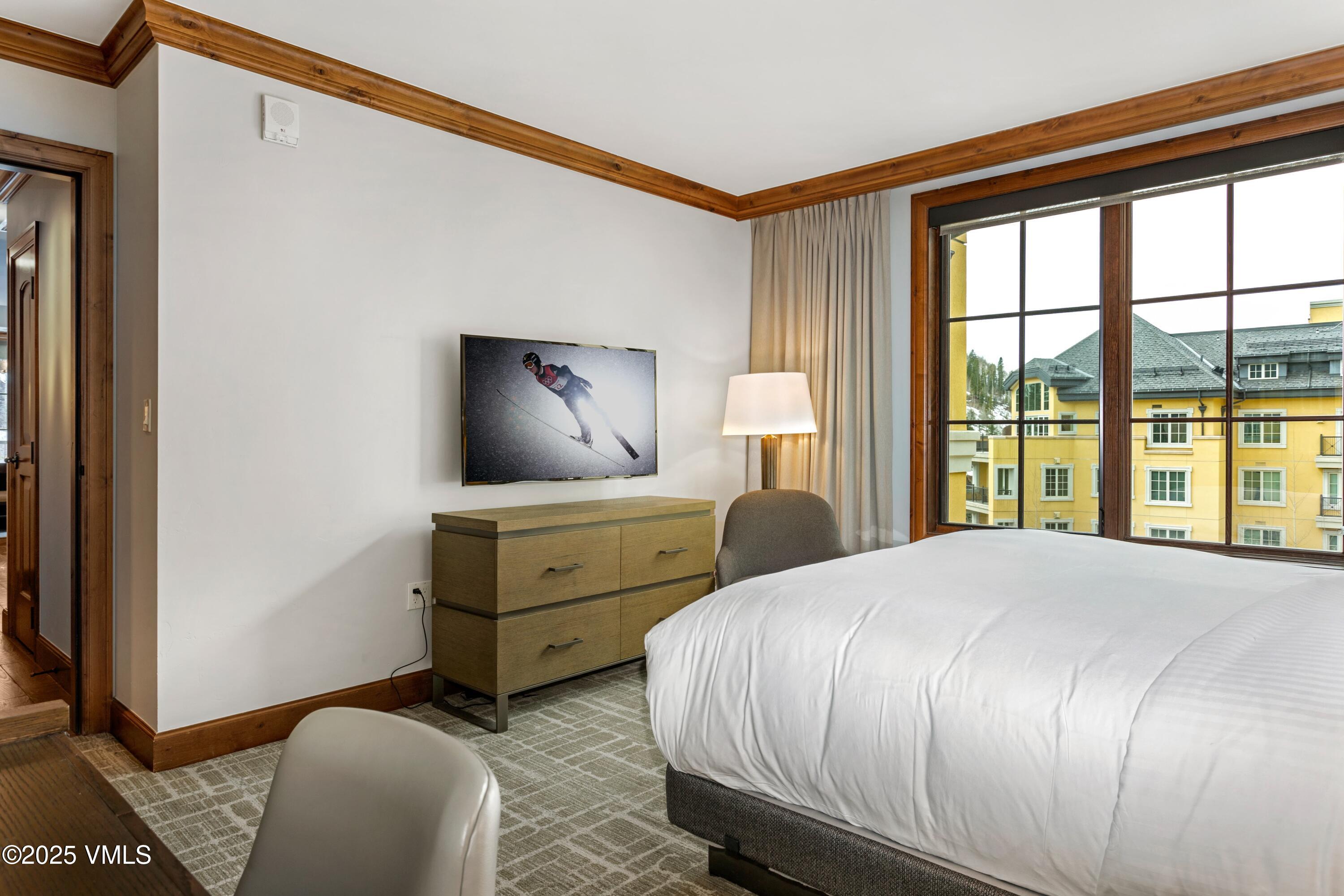 728 West Lionshead Circle, Unit F429 Vail, CO 81657 - Photo 12 of 25 a bedroom with a bed and a flat tv screen on dresser