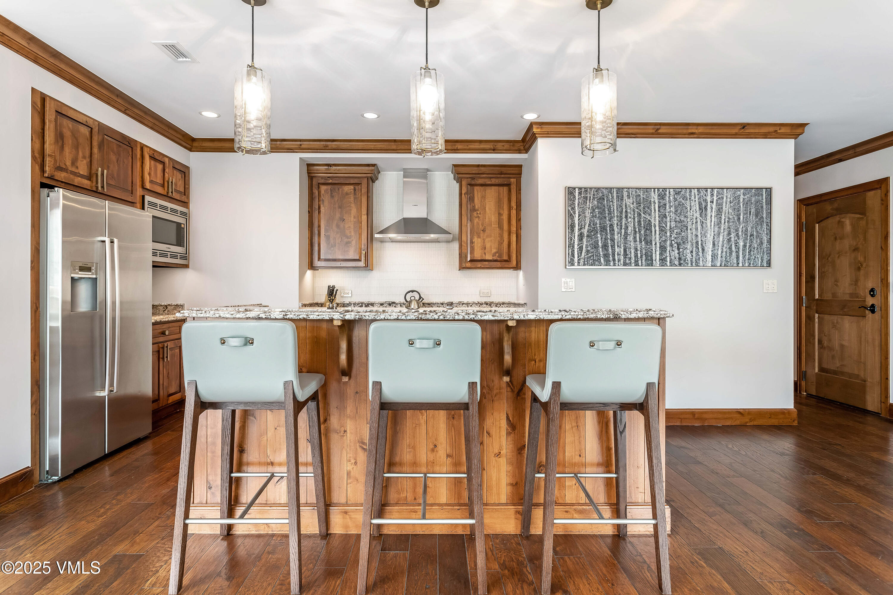 728 West Lionshead Circle, Unit F429 Vail, CO 81657 - Photo 22 of 25 a room with stainless steel appliances kitchen island granite countertop a refrigerator a stove a kitchen island with wooden floor and cabinets