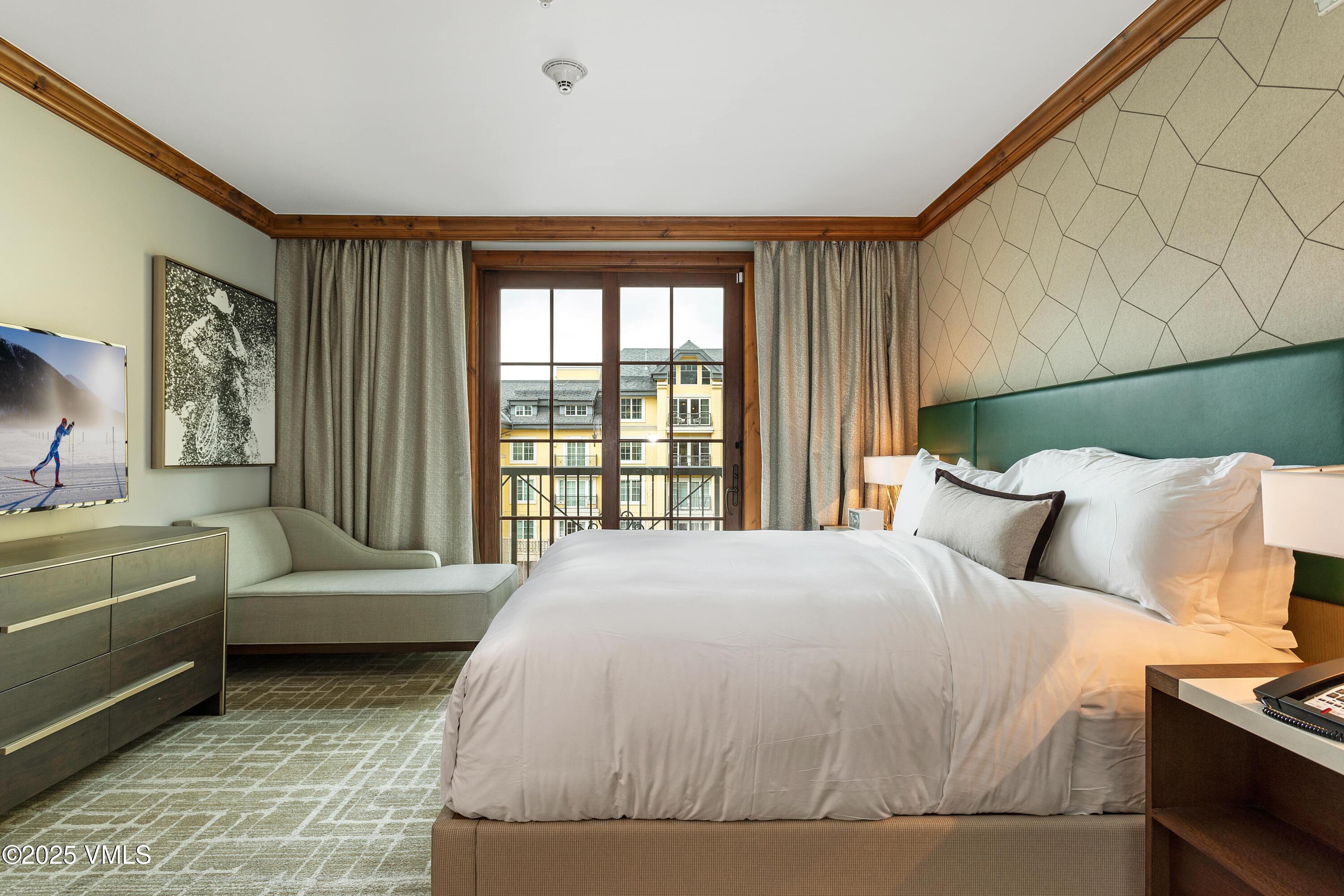 728 West Lionshead Circle, Unit F429 Vail, CO 81657 - Photo 3 of 25 a bed sitting in a bedroom next to a window