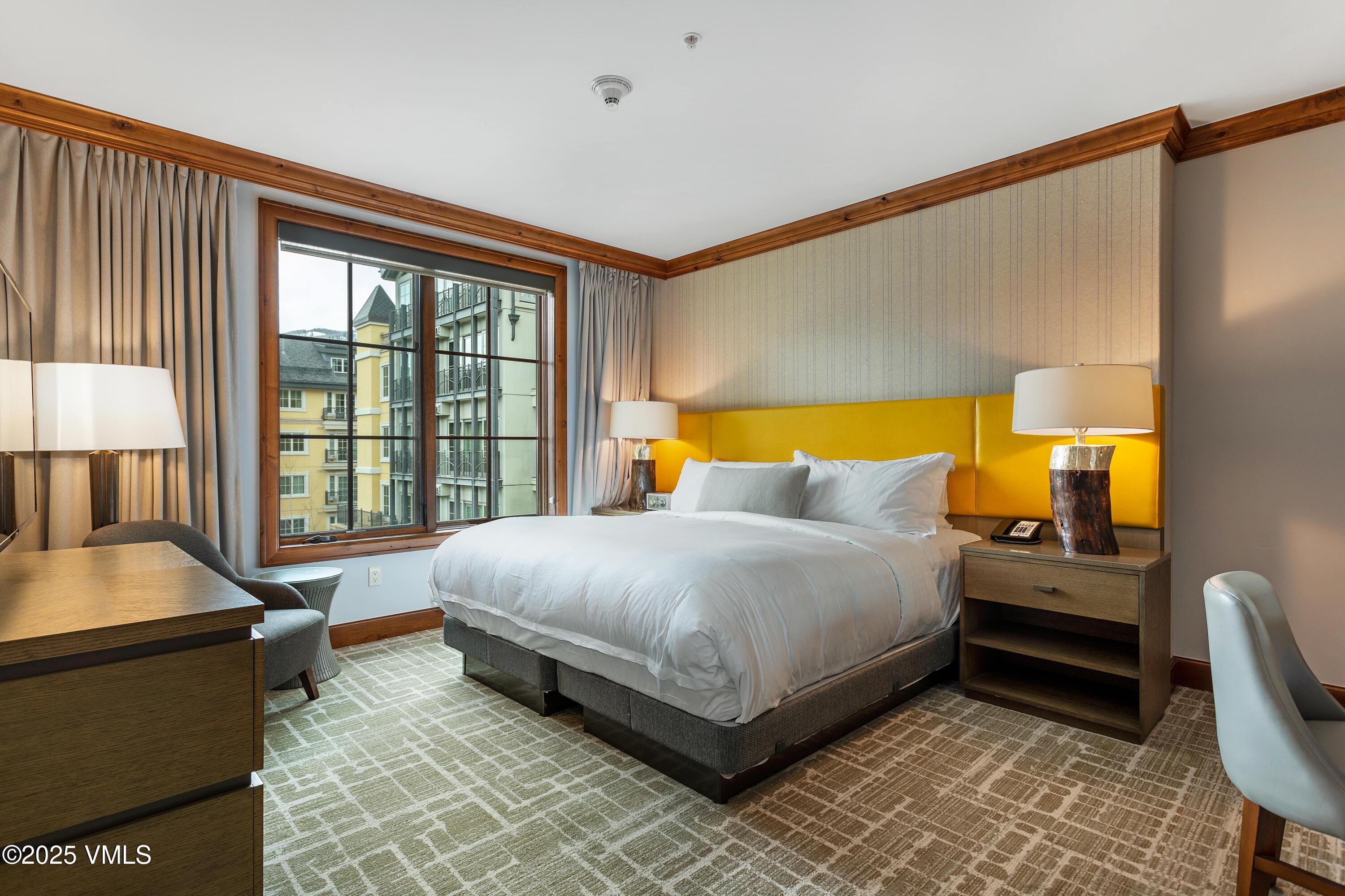 728 West Lionshead Circle, Unit F429 Vail, CO 81657 - Photo 9 of 25 a bedroom with a bed and wooden floor