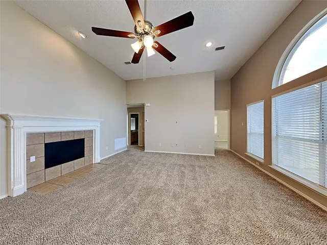 an empty room with fan and windows