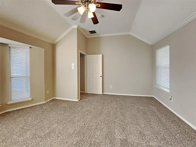 an empty room with fan and windows