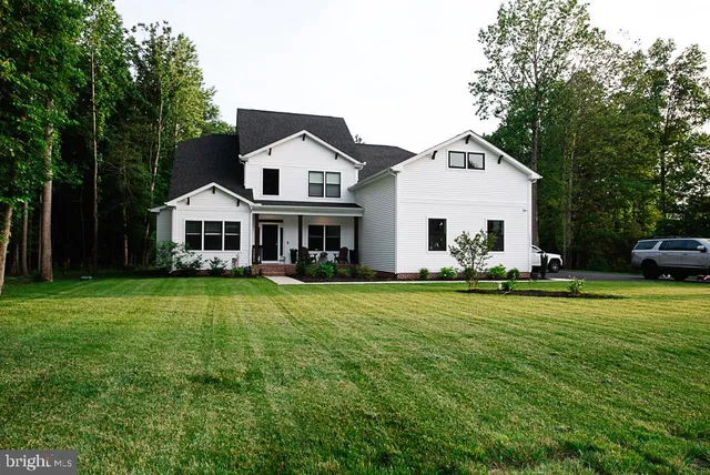 a front view of a house with a yard and trees