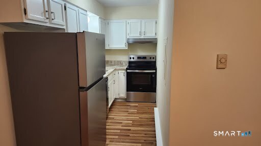 115 Short Beach Road, Unit 304 Stratford, CT 06615 - Photo 11 of 26 a kitchen with stainless steel appliances a refrigerator and a stove