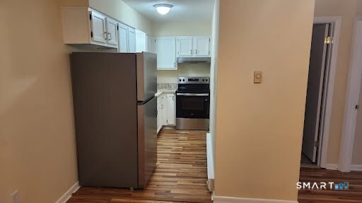 115 Short Beach Road, Unit 304 Stratford, CT 06615 - Photo 19 of 26 a kitchen with refrigerator and cabinets