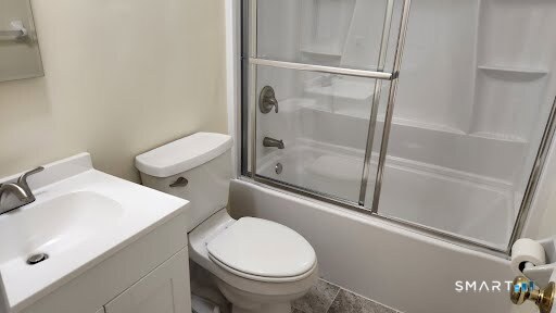 115 Short Beach Road, Unit 304 Stratford, CT 06615 - Photo 21 of 26 a white toilet sitting next to a bath tub