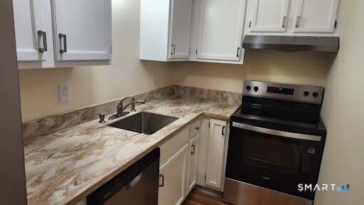 115 Short Beach Road, Unit 304 Stratford, CT 06615 - Photo 23 of 26 a kitchen with granite countertop a stove sink and cabinets