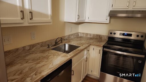 115 Short Beach Road, Unit 304 Stratford, CT 06615 - Photo 25 of 26 a kitchen with granite countertop a sink stove and cabinets