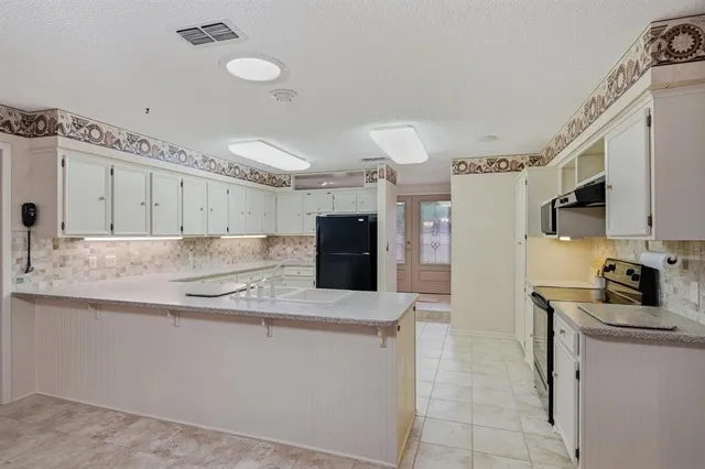 a kitchen with stainless steel appliances granite countertop a sink and a refrigerator
