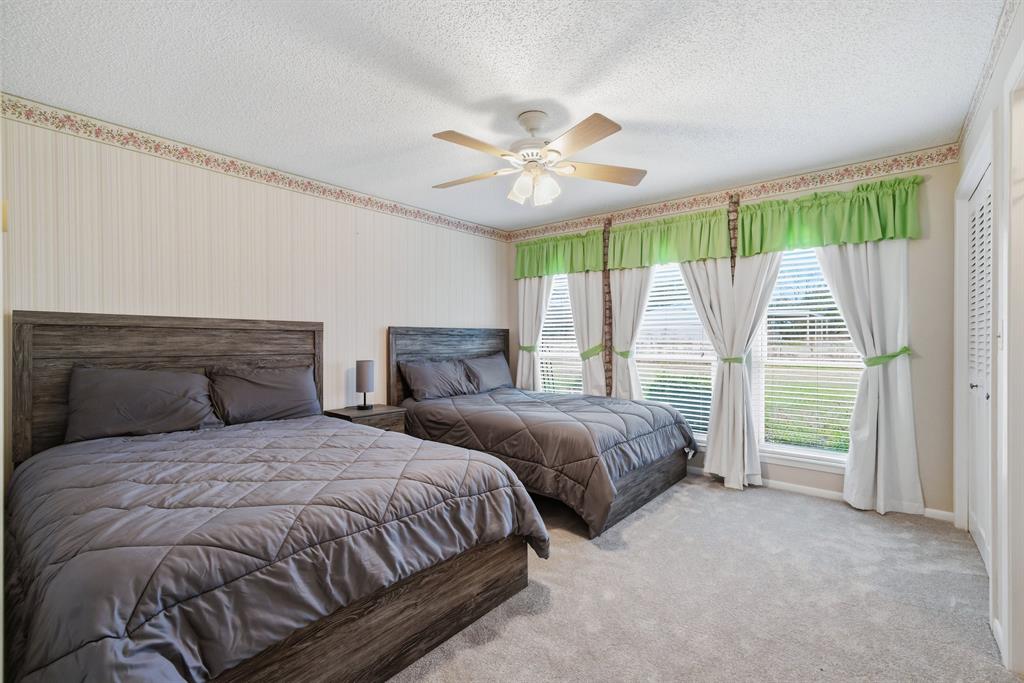 776 County Road 3209 Wills Point, TX 75169 - Photo 28 of 40 a bedroom with two large bed and a chandelier