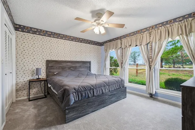 a bedroom with a bed and a large window with outer view