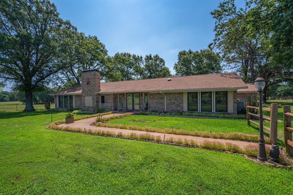 776 County Road 3209 Wills Point, TX 75169 - Photo 9 of 40 a front view of a house with a yard table and chairs