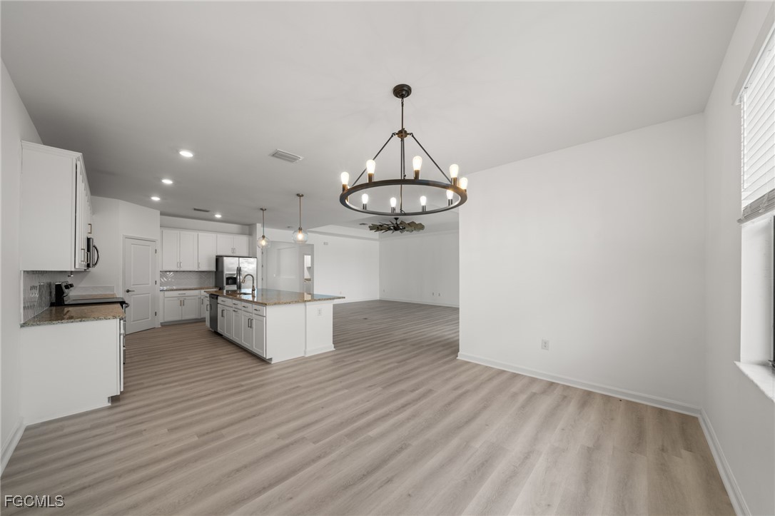 11559 Canopy Loop Fort Myers, FL 33913 - Photo 13 of 50 a view of a kitchen with granite countertop wooden floor stainless steel appliances and a window