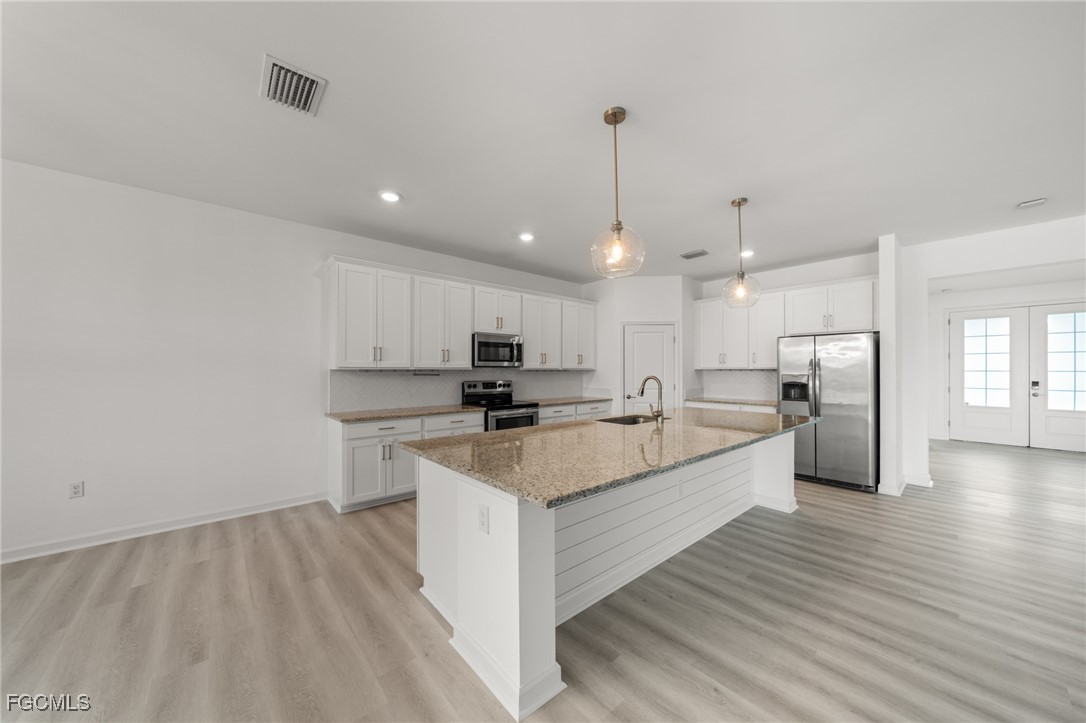 11559 Canopy Loop Fort Myers, FL 33913 - Photo 14 of 50 a large white kitchen with a large counter top a sink stainless steel appliances and cabinets