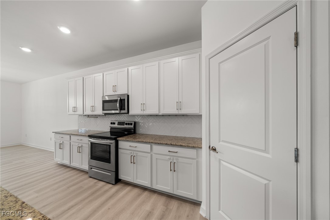 11559 Canopy Loop Fort Myers, FL 33913 - Photo 18 of 50 a kitchen with granite countertop white cabinets and stainless steel appliances