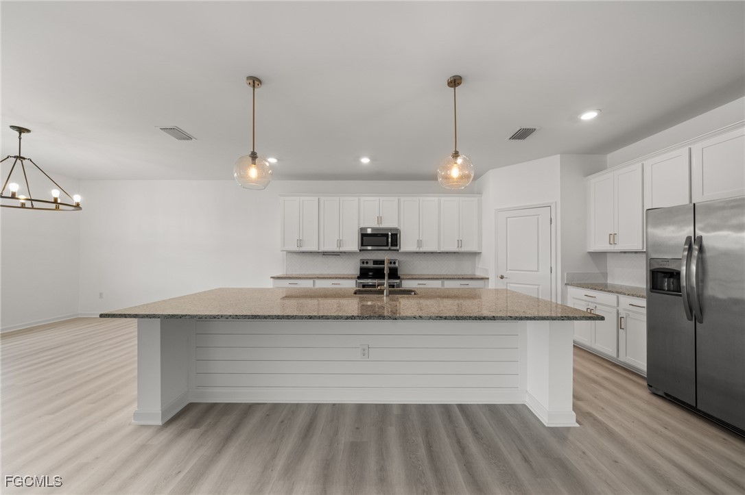 11559 Canopy Loop Fort Myers, FL 33913 - Photo 19 of 50 a large kitchen with granite countertop a stove a sink and a refrigerator