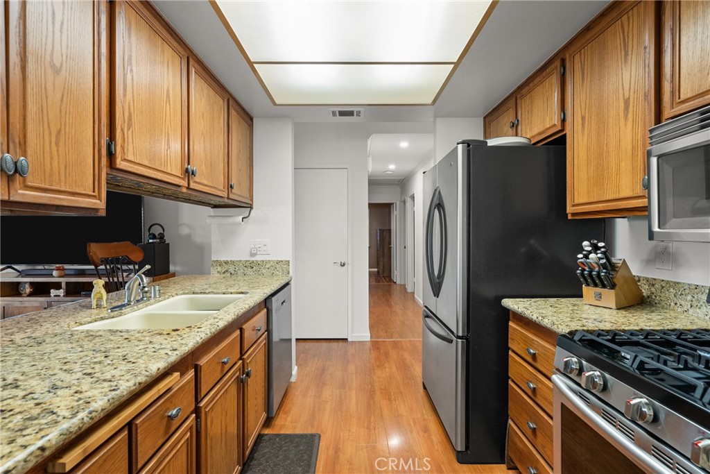 31436 Arrow Point Drive Castaic, CA 91384 - Photo 24 of 76 a kitchen with granite countertop a sink a stove cabinets and refrigerator