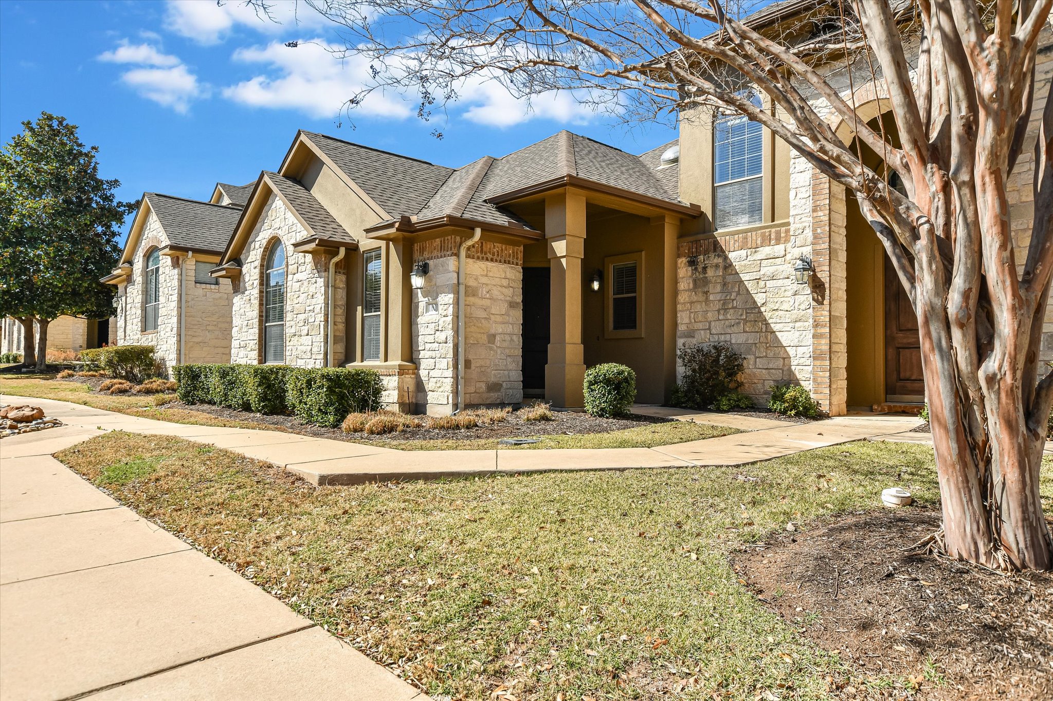 14100 Avery Ranch Boulevard, Unit 1101 Austin, TX 78717 - Photo 1 of 25 View of front facade featuring stone siding, roof with shingles, and a front yard