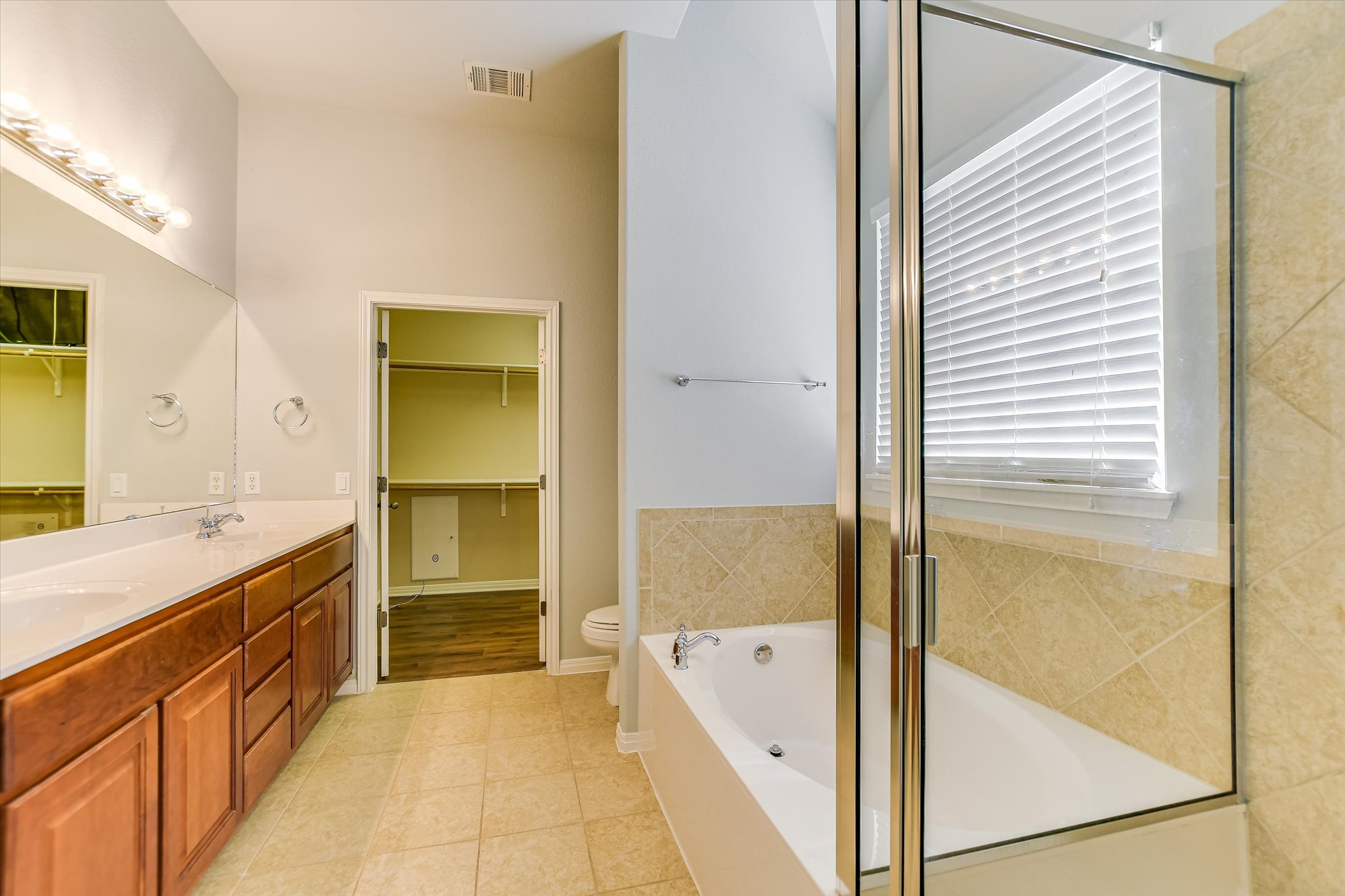 14100 Avery Ranch Boulevard, Unit 1101 Austin, TX 78717 - Photo 13 of 25 Bathroom with double vanity, a bath, light tile patterned floors, a shower stall, and a walk in closet