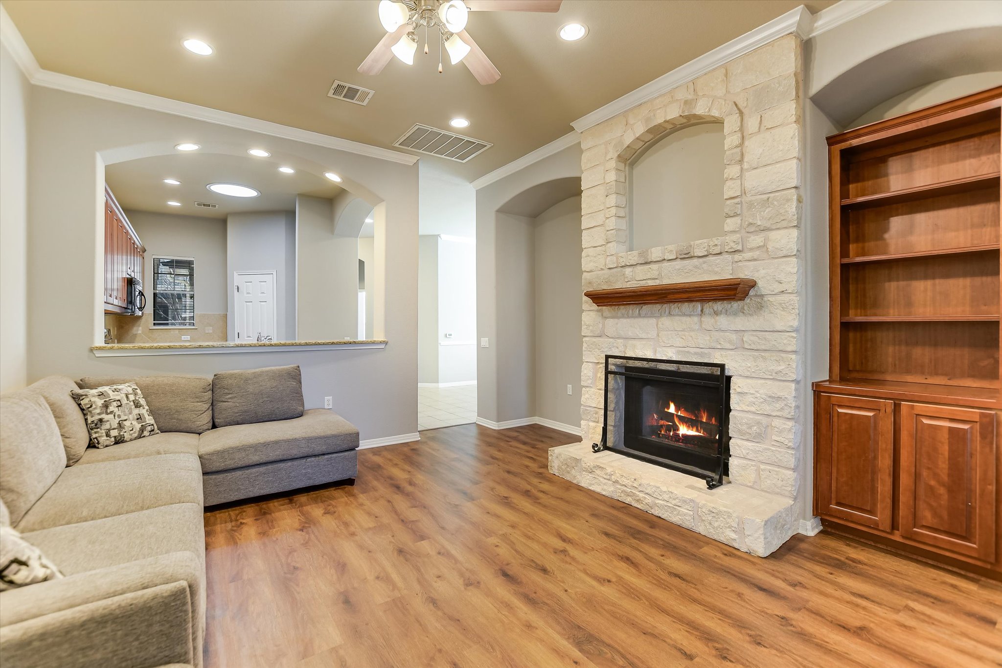 14100 Avery Ranch Boulevard, Unit 1101 Austin, TX 78717 - Photo 2 of 25 Living area featuring ornamental molding, ceiling fan, wood finished floors, recessed lighting, and a fireplace