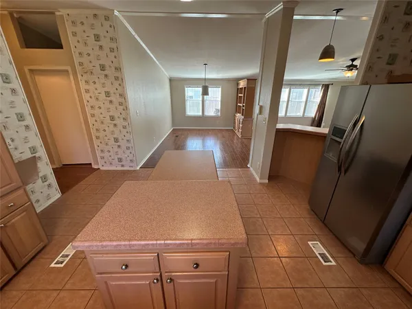a kitchen with granite countertop a refrigerator and a stove top oven