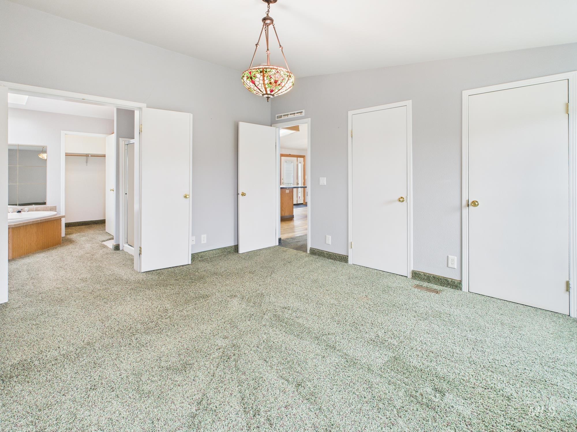 523 3rd Street Ferdinand, ID 83526 - Photo 12 of 41 Unfurnished bedroom featuring light colored carpet and multiple closets