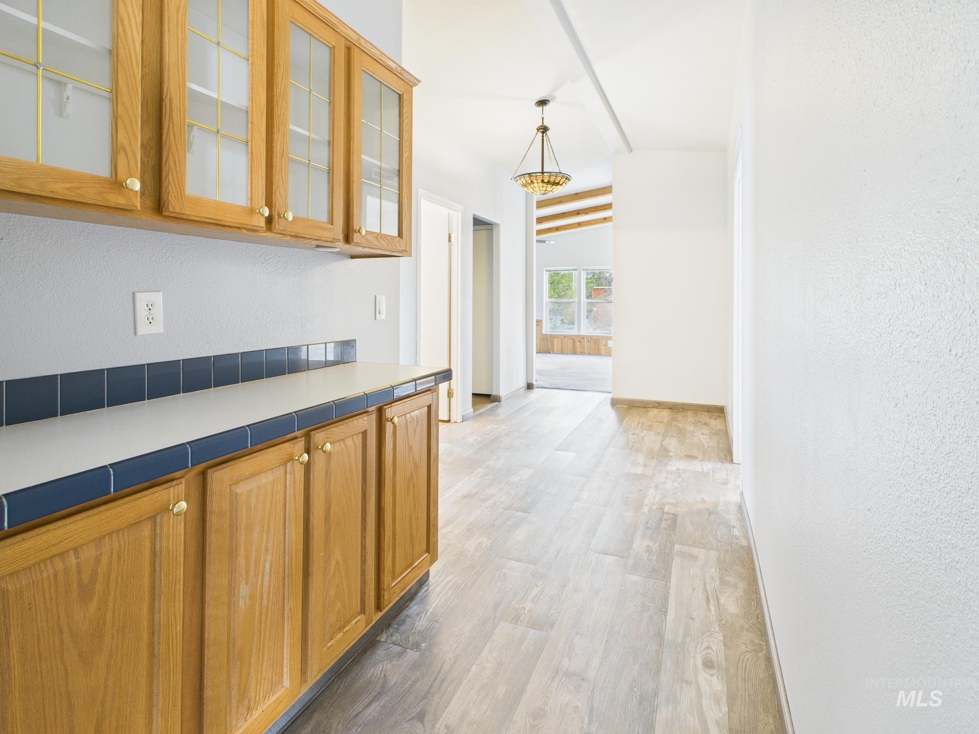 523 3rd Street Ferdinand, ID 83526 - Photo 17 of 41 Corridor featuring a textured wall, light wood finished floors, vaulted ceiling, and a chandelier