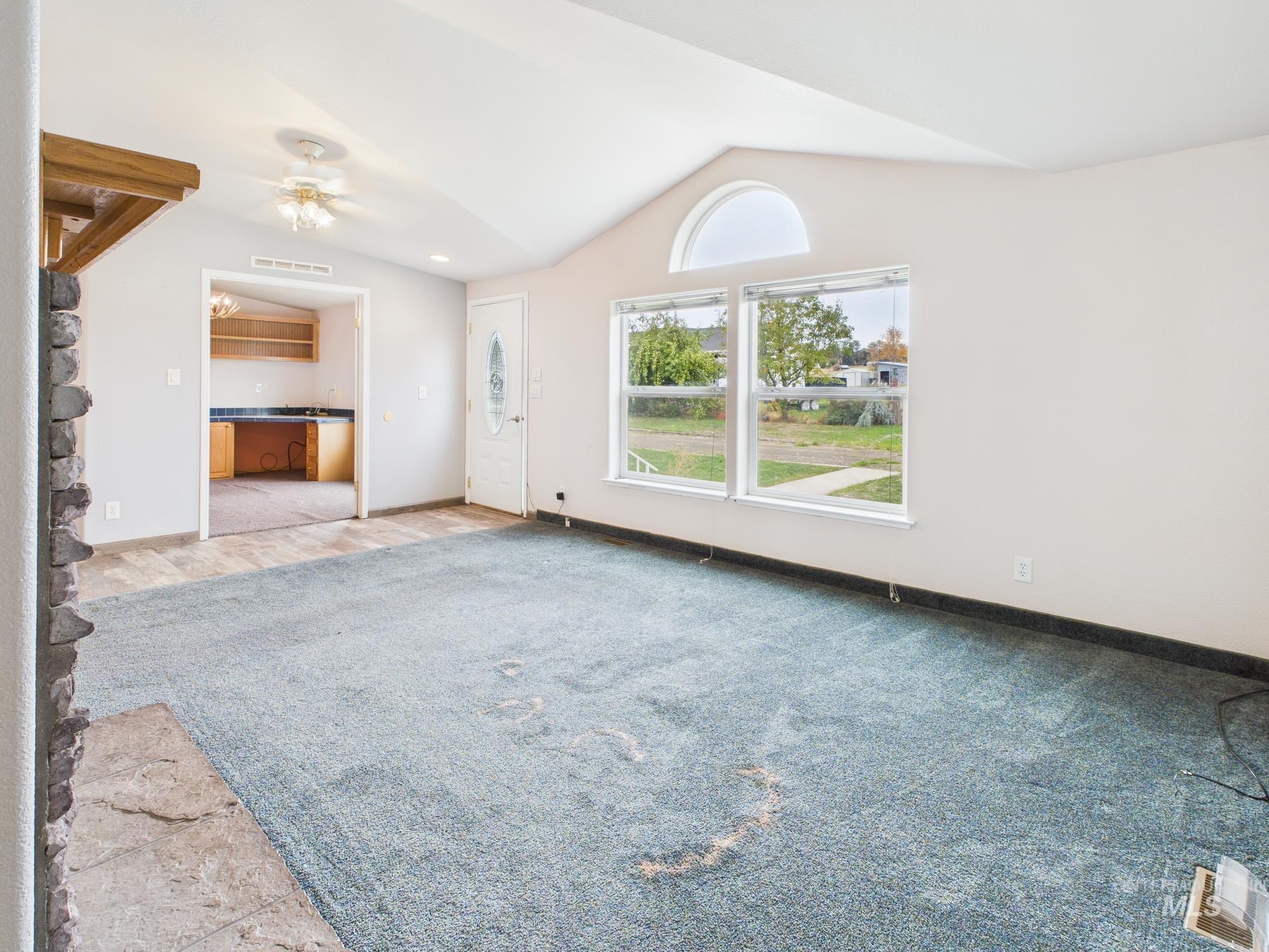 523 3rd Street Ferdinand, ID 83526 - Photo 5 of 41 Unfurnished living room with vaulted ceiling, light colored carpet, and ceiling fan