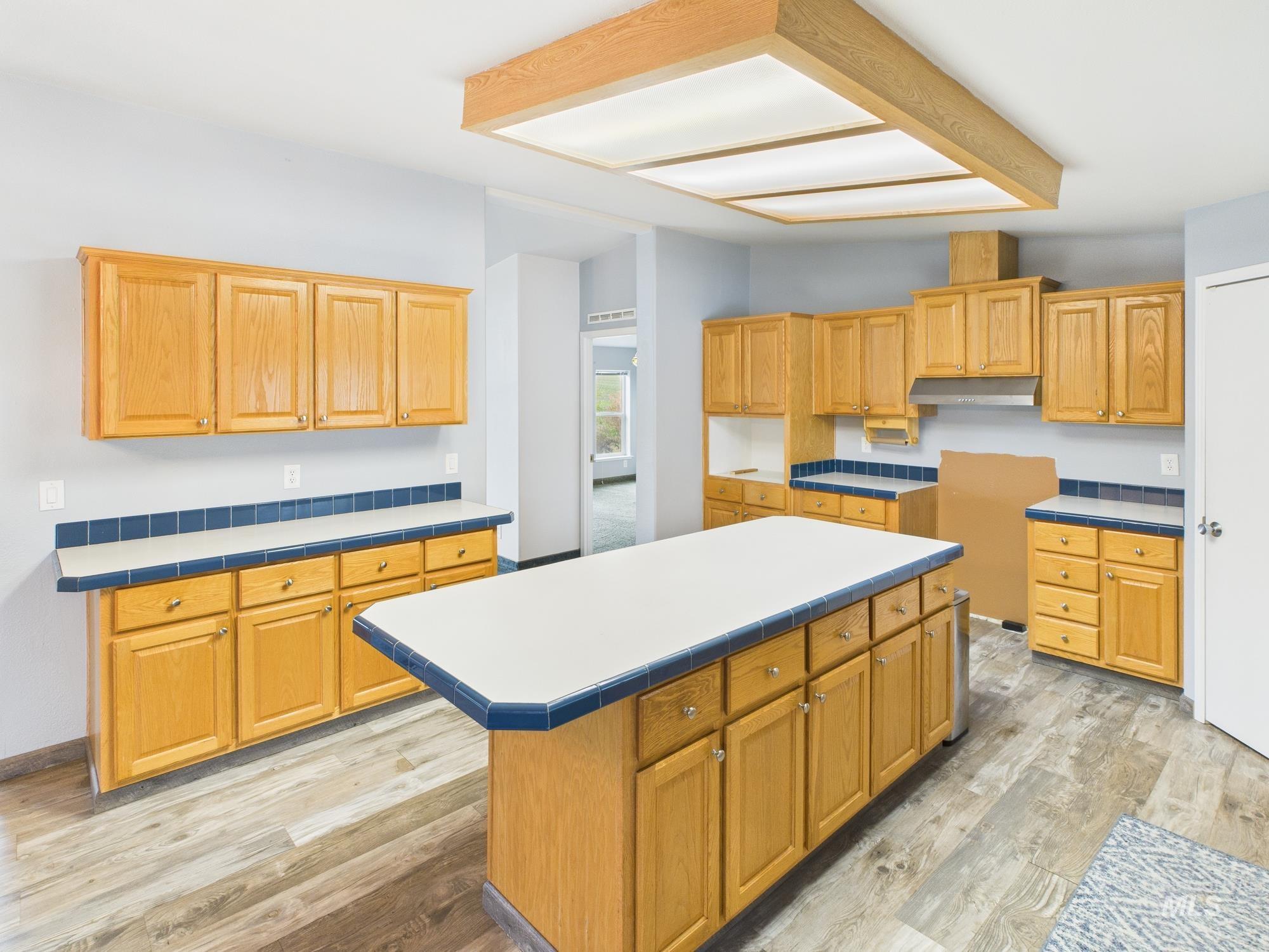 523 3rd Street Ferdinand, ID 83526 - Photo 8 of 41 Kitchen with a center island, light wood-type flooring, light countertops, and under cabinet range hood