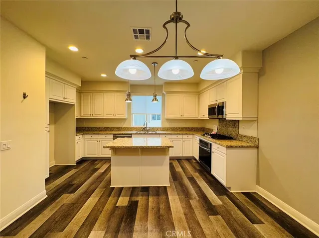 a large kitchen with stainless steel appliances granite countertop a sink and cabinets