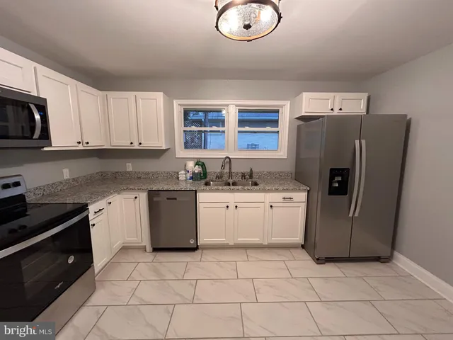 a kitchen with a refrigerator sink and cabinets