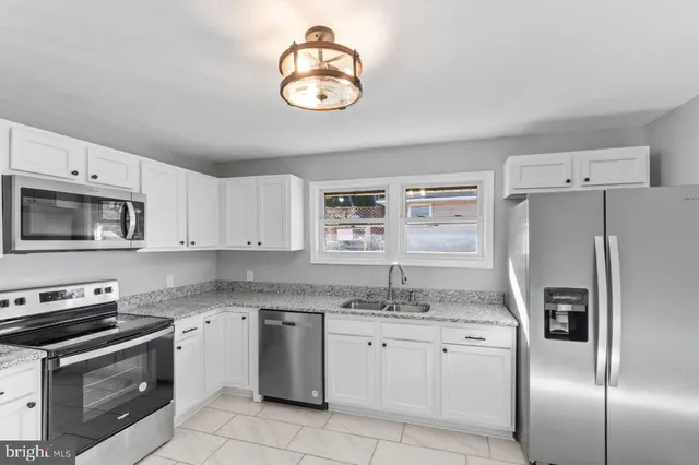 a kitchen with stainless steel appliances granite countertop a refrigerator sink and stove