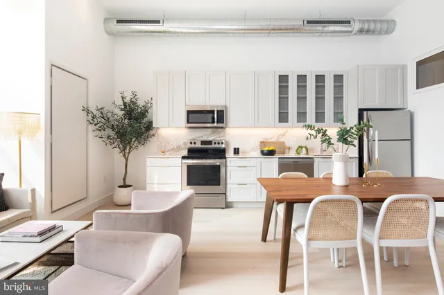 a dining room with furniture and a kitchen view