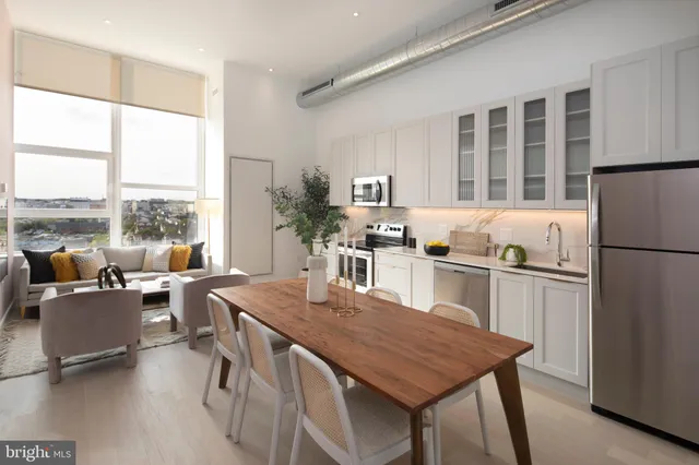 a living room with furniture a large window and kitchen view
