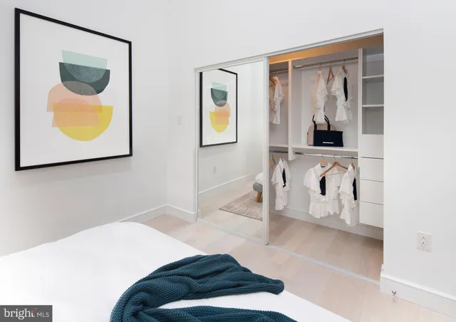 a bedroom with a bed and a painting on the wall