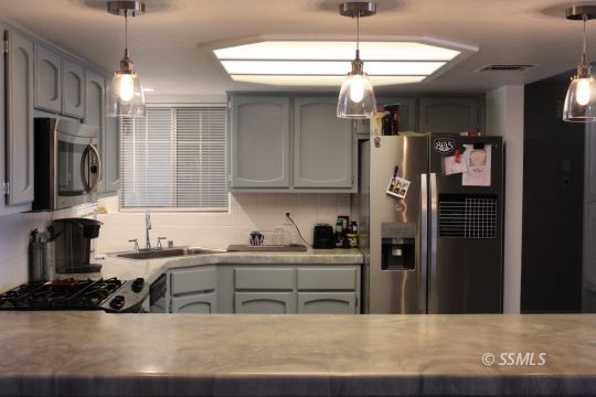 401 Ashton Street Ridgecrest, CA 93555 - Photo 9 of 36 a kitchen with a sink a refrigerator and cabinets